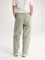 A person shown from the back wearing light sage green cargo pants, a white short-sleeve top, and light green sneakers against a plain light gray studio background. - Arc'teryx Nia Pants (Women's) - Habitat