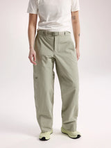 A model wearing light sage green relaxed-fit pants with a matching belt, styled with a white t-shirt and light green sneakers against a plain light background. - Arc'teryx Nia Pants (Women's) - Habitat