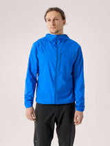 Man wearing a blue jacket and black pants on a light gray background - Arc'teryx Squamish Hoody (Men's) - Fluidity