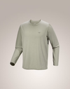 A light sage green long-sleeve crewneck shirt with a small Arc'teryx logo on the left chest, displayed on a neutral beige gradient background.  - Arc'teryx Cormac Crew Neck Shirt Long Sleeve (Men's) - Habitat