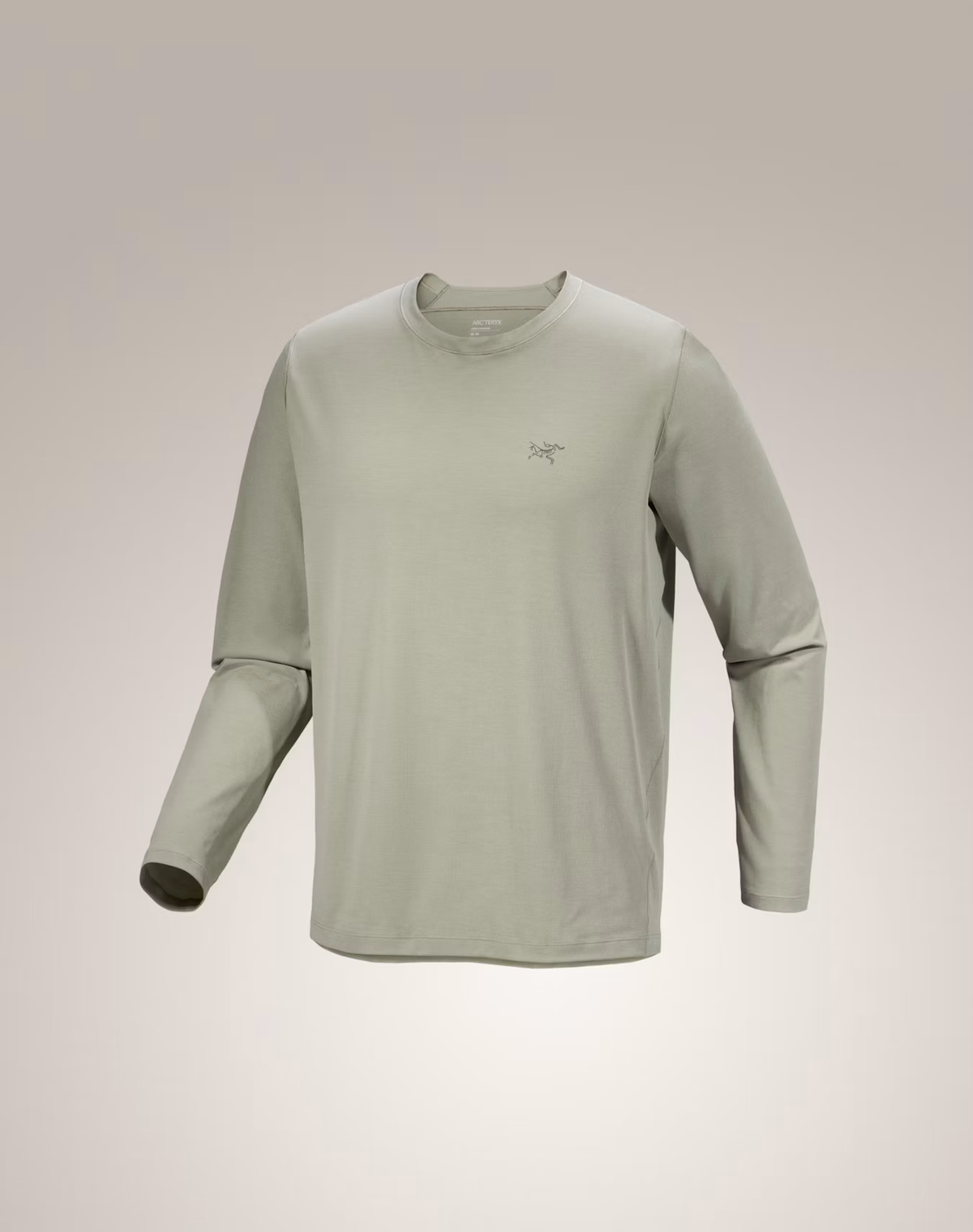 A light sage green long-sleeve crewneck shirt with a small Arc'teryx logo on the left chest, displayed on a neutral beige gradient background.  - Arc'teryx Cormac Crew Neck Shirt Long Sleeve (Men's) - Habitat