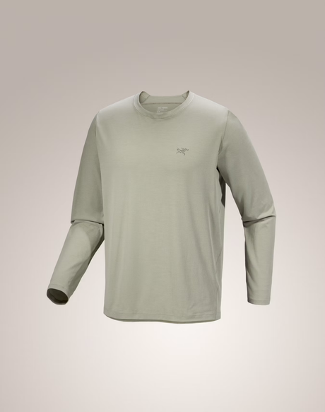 A light sage green long-sleeve crewneck shirt with a small Arc'teryx logo on the left chest, displayed on a neutral beige gradient background.  - Arc'teryx Cormac Crew Neck Shirt Long Sleeve (Men's) - Habitat