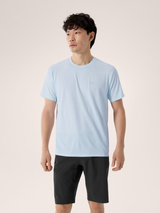 Man wearing a light blue t-shirt and black shorts on a plain background - Arc'teryx Cormac Crew Neck Shirt Short Sleeve (Men's) - Alpine Blue