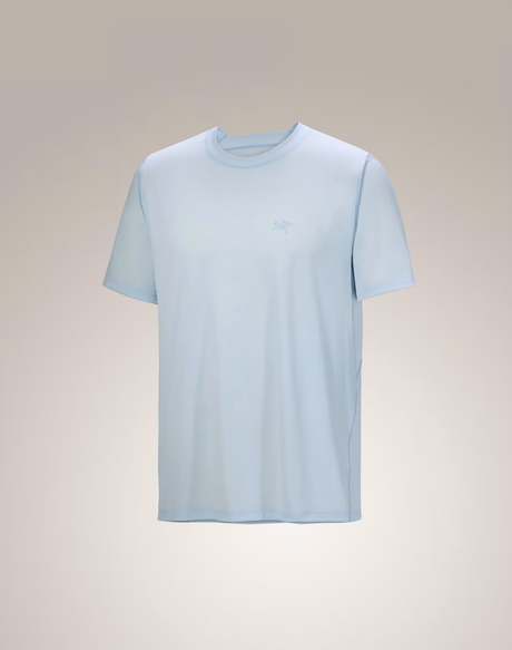 A light blue short-sleeve crewneck t-shirt with a small tonal logo on the left chest, displayed against a neutral beige gradient background. - Arc'teryx Cormac Crew Neck Shirt Short Sleeve (Men's) - Alpine Blue