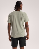 Person wearing a light green t-shirt and black shorts on a plain background - Arc'teryx Cormac Crew Neck Shirt Short Sleeve (Men's) - Habitat