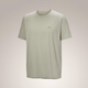 A light sage green short-sleeve crewneck t-shirt with a small embroidered Arc'teryx logo on the left chest, displayed against a neutral beige gradient background. - Arc'teryx Cormac Crew Neck Shirt Short Sleeve (Men's) - Habitat