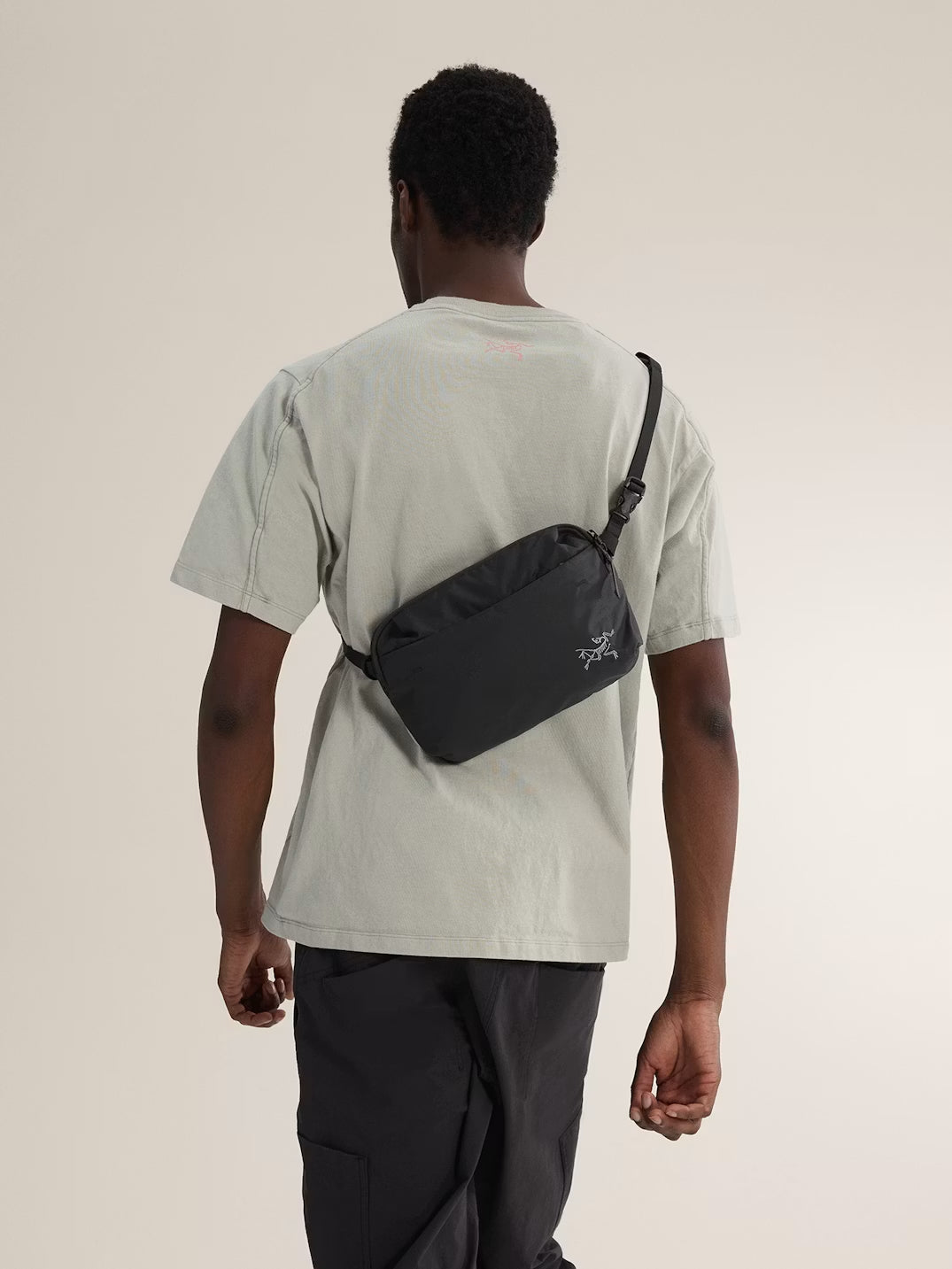 Person wearing a black waist bag on a plain background - Arc'teryx Heliad Crossbody Bag - Black