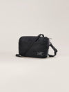 A black nylon crossbody bag with a silver Arc'teryx logo on the front, displayed on a clean, light beige studio background. - Arc'teryx Heliad Crossbody Bag - Black