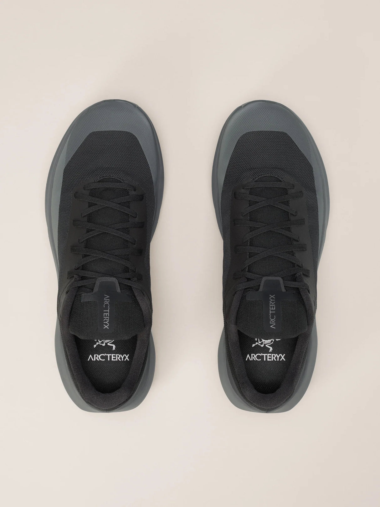 A pair of Arc'teryx low-top sneakers shown from a top-down view on a light beige background. The shoes are primarily black with dark gray accents on the toe and heel areas. - Arc'teryx Norvan LD 4 Shoes (Men's) - Black/Graphite