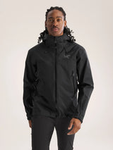 Person wearing a black jacket with a brand logo on a light gray background - Arc'teryx Beta SL Jacket (Men's) - Black
