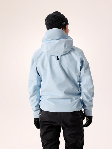 Person wearing a light blue jacket and black pants on a white background - Arc'teryx Alpha SV Jacket (Women's) - Alpine Blue/Black