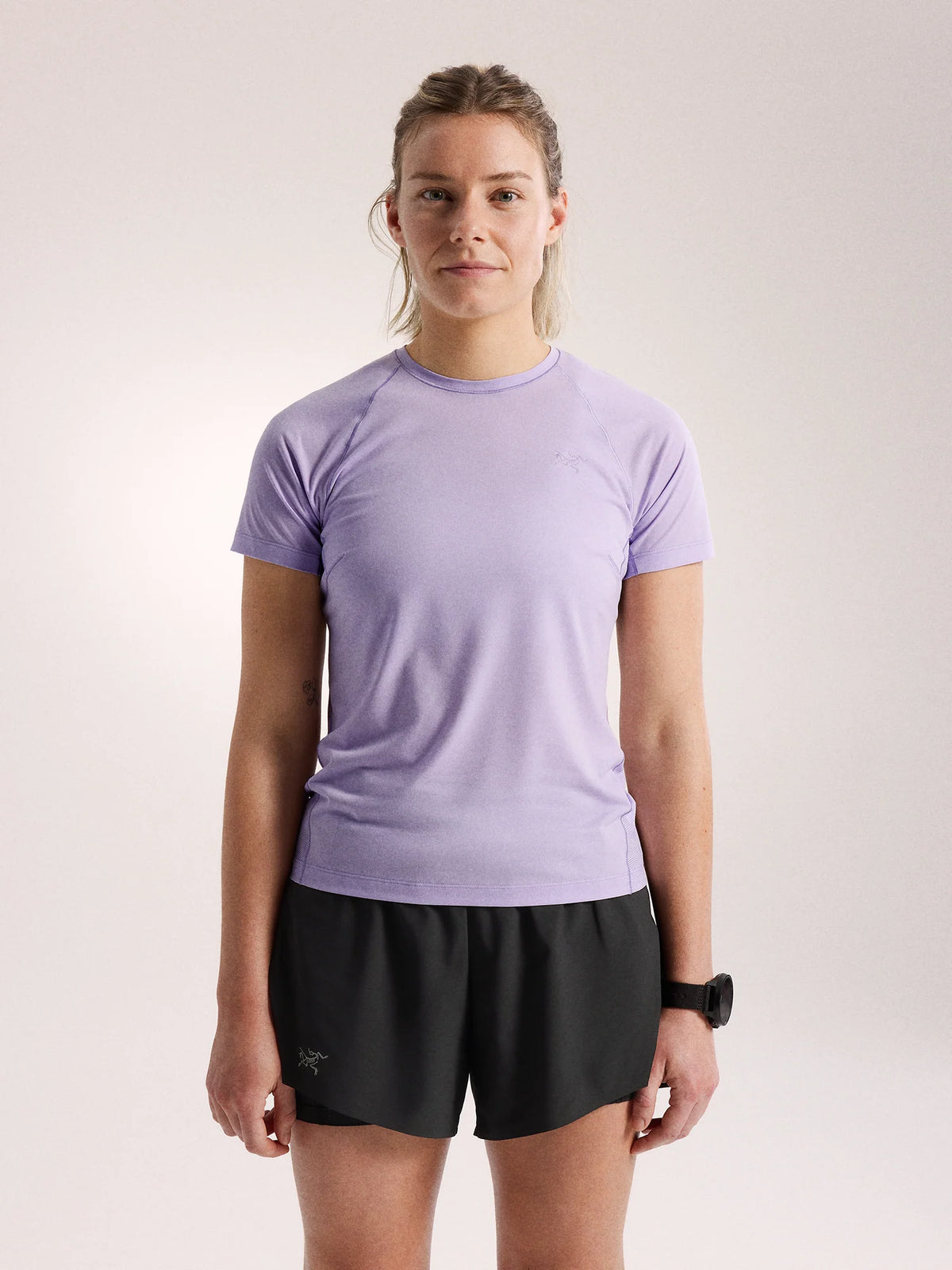 Person wearing a light purple t-shirt and black shorts on a plain background - Arc'teryx Norvan Crew Short Sleeve (Women's) - Mallow