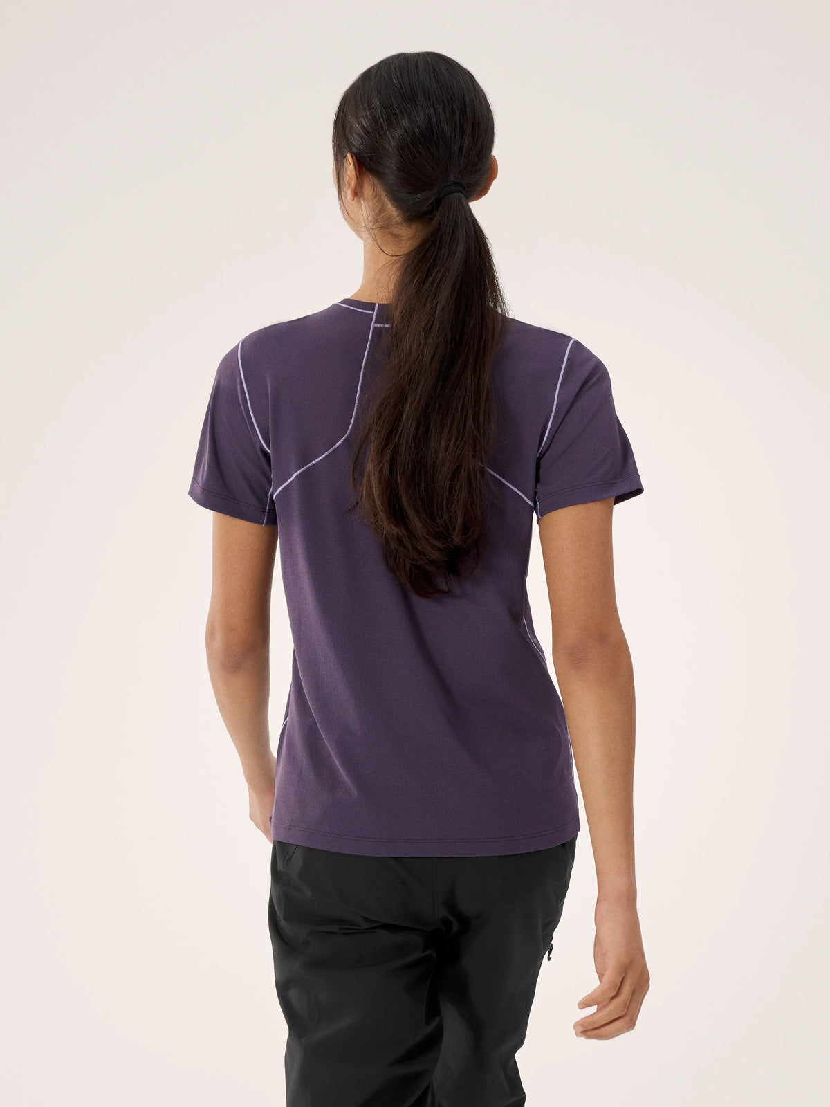 Person wearing a purple athletic shirt with white accents on a plain background - Arc'teryx Sunna Crew Shirt Short Sleeve (Women's) - Moondrop