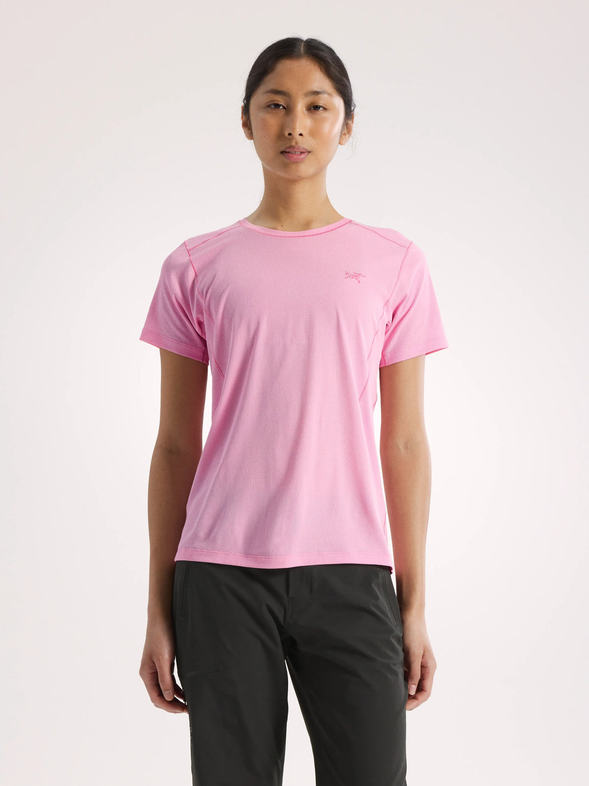 Person wearing a pink t-shirt and black pants on a light pink background - Arc'teryx Sunna Crew Shirt Short Sleeve (Women's) - Pineberry