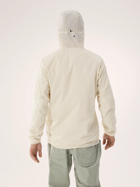 A person shown from the back wearing a light cream hooded jacket and light sage green pants against a plain light background. - Arc'teryx Squamish Hoody (Men's) - Sea Salt