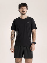 Man wearing a black t-shirt and shorts with a logo on a beige background - Arc'teryx Norvan Downword Logo Shirt Short Sleeve (Men's) - Black