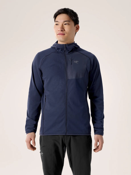 Man wearing a navy blue jacket with a brand logo on a beige background - Arc'teryx Delta Hoody (Men's) - Black Sapphire