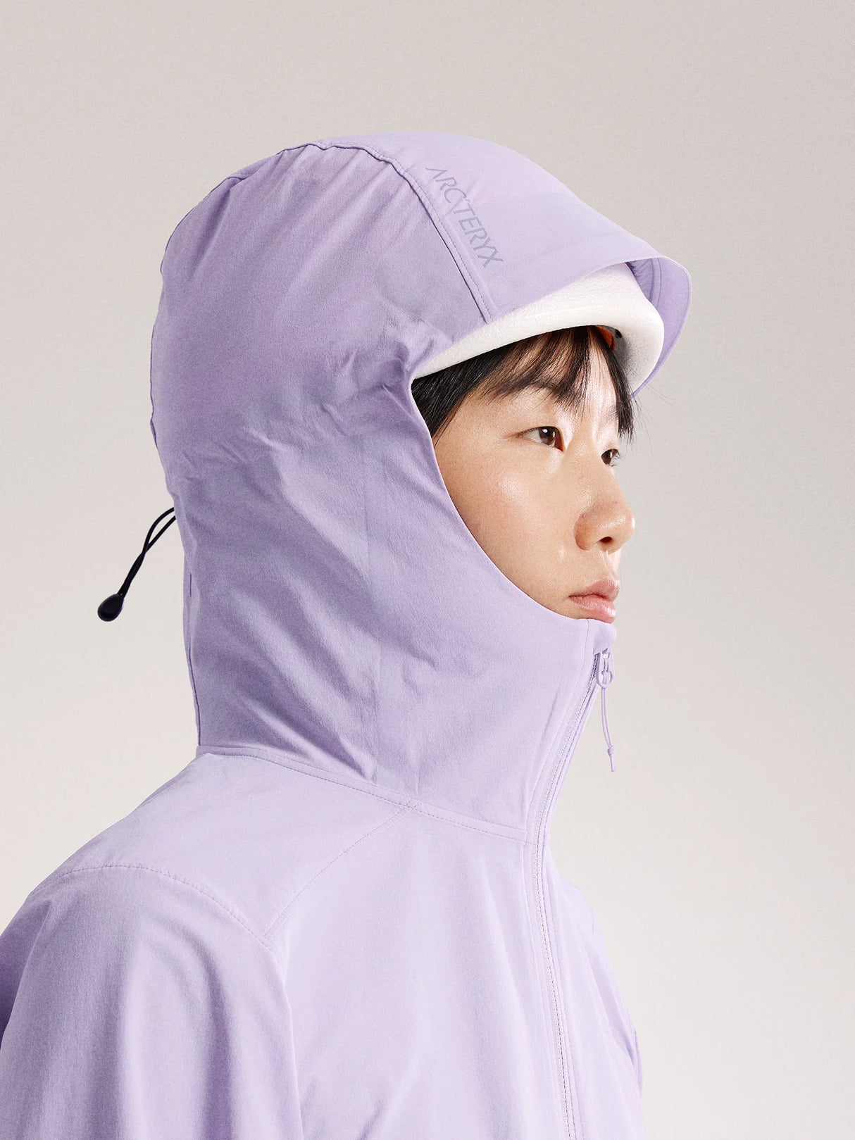 Person wearing a light purple hooded jacket with a white interior on a plain background - Arc'teryx Gamma Lightweight Hoody (Women's) - Mallow