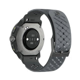 A rugged smartwatch shown from the back, featuring a dark gray textured silicone strap and a metallic gray circular sensor face on a white background. - Suunto Race S Titanium GPS Sports Watch