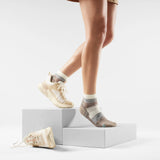 Person wearing patterned socks with sneakers on a white background - Smartwool Hike Margarita Light Cushion Ankle Socks (Women's) - Natural