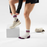 Person wearing white socks with purple accents and white sneakers on a light gray background - Smartwool Run Targeted Cushion Mid Crew Socks (Women's) - Ash
