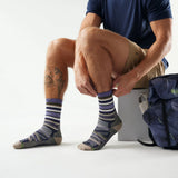 Person wearing striped socks sitting with a backpack on a white background - Smartwool Hike Panorama Light Cushion Crew Socks (Unisex) - Nightfall Blue