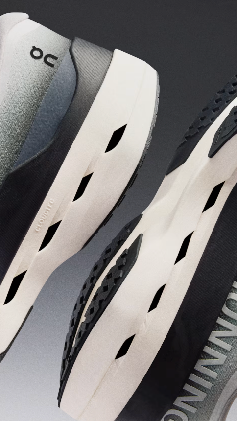 Close-up of white on cloudboom mac running shoes with black sole on a dark background