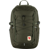 An olive green Fjälleväl backpack with a front zippered pocket, elastic cord compression system, and a small red brand patch on a white background. - Fjällräven Skule 20 Backpack - Deep Forest