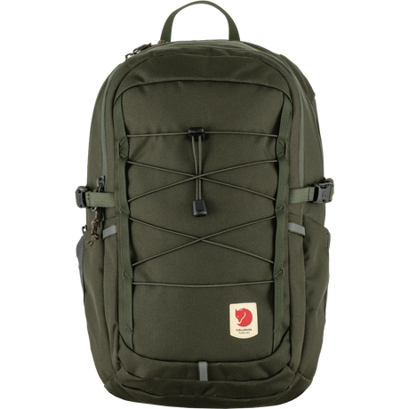 An olive green Fjälleväl backpack with a front zippered pocket, elastic cord compression system, and a small red brand patch on a white background. - Fjällräven Skule 20 Backpack - Deep Forest