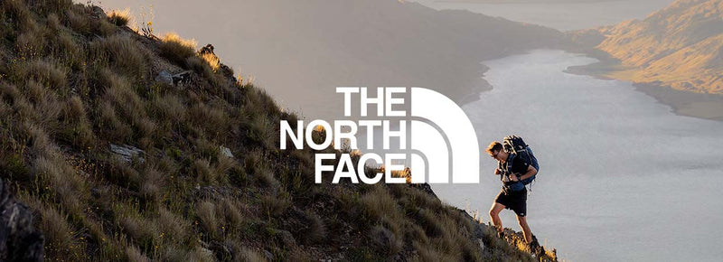 man hiking on a mountain in outdoor wear and a the north face logo overlayed in white