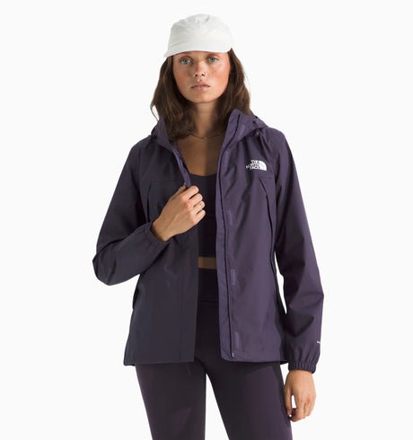 Woman wearing a the north face antora rain jacket in purple with the brand logo on the chest. with white background