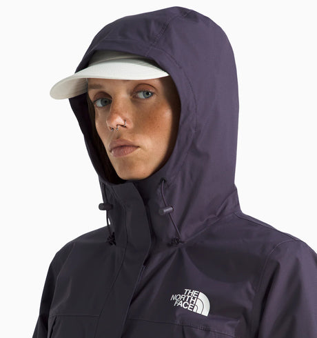 Woman wearing a the north face antora rain jacket in purple with the brand logo on the chest. with white background