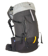 A large technical hiking backpack shown from the side against a plain white background. The backpack features a dark gray and black grid-patterned main body, a light gray top rain cover, black straps and buckles, and a small yellow accent on the lower front pocket. - One Planet Tussock 60L Pack - Black