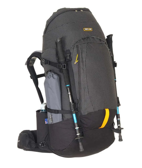 A black and gray technical hiking backpack with yellow accents, shown on a white background with two trekking poles and a water bottle attached. - One Planet Tussock 60L Pack - Black