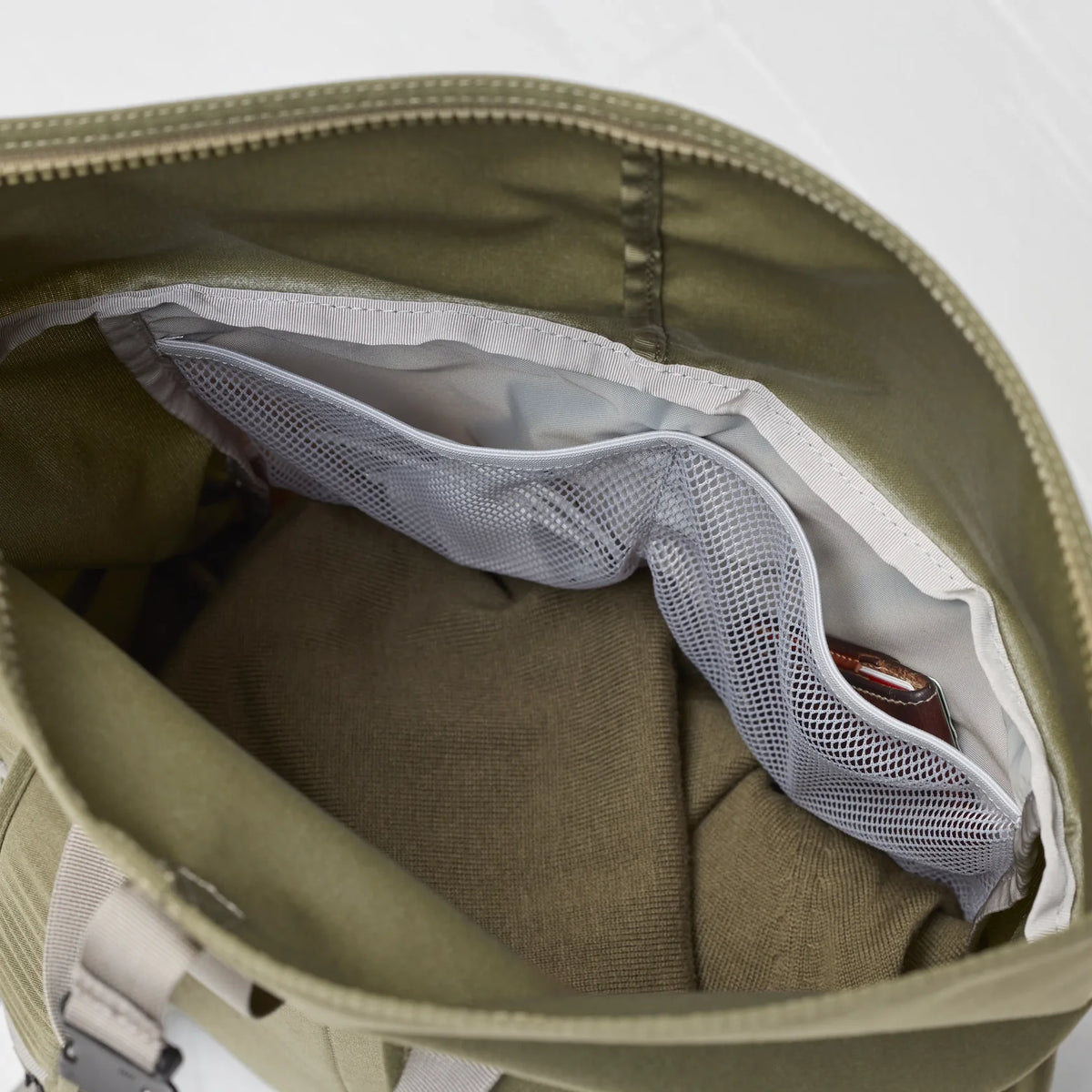 Open green bag with a white mesh pocket on a light gray background - Fjällräven Vardag Foldsack 25 - Green/Clay