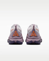 A Nike ACG ZEGAMA ZOOMX trail running shoe in a light lavender and purple colorway, featuring a textured mesh upper, a purple Swoosh, and a purple Vibram outsole, shown from a side profile on a light gray background.