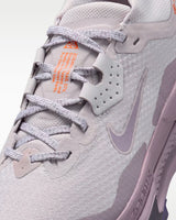 A Nike ACG ZEGAMA ZOOMX trail running shoe in a light lavender and purple colorway, featuring a textured mesh upper, a purple Swoosh, and a purple Vibram outsole, shown from a side profile on a light gray background.