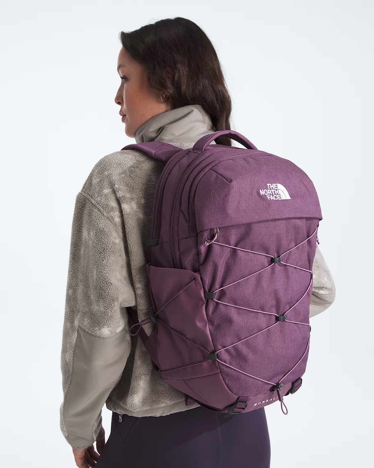 A woman shown from the back wearing a purple The North Face backpack, styled with a gray textured jacket against a plain white studio background. - The North Face Borealis Backpack (Women's) - Chroma Purple Light Heather/Hushed Lavender