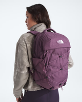 A woman shown from the back wearing a purple The North Face backpack, styled with a gray textured jacket against a plain white studio background. - The North Face Borealis Backpack (Women's) - Chroma Purple Light Heather/Hushed Lavender
