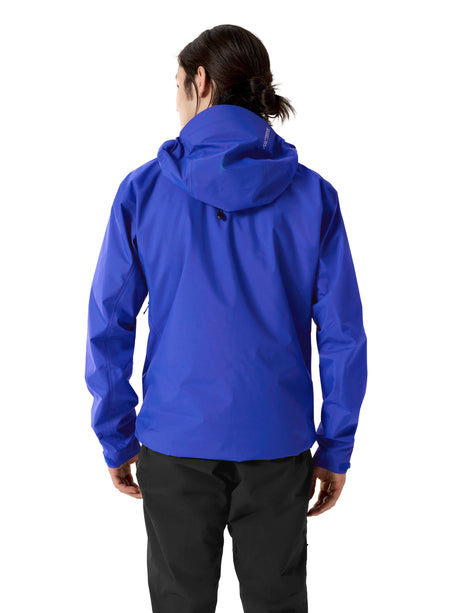 A person shown from the back wearing a bright royal blue hooded jacket and dark pants against a plain white studio background. - Arc'teryx Beta SL GORE-TEX Jacket (Men's) - Vitality II
