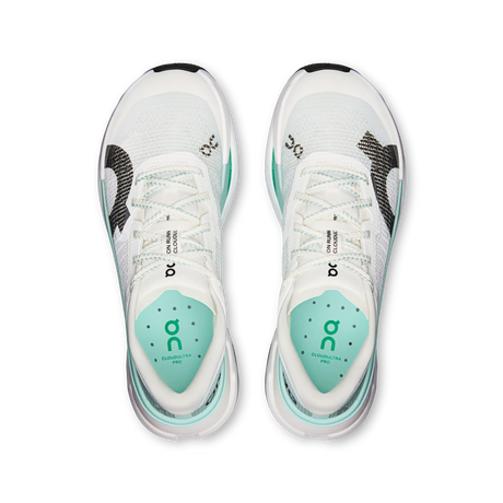 A pair of On Cloudrunner 300 running shoes shown from a top-down view, featuring a white mesh upper with mint green accents, black and white textured side panels, and a white midsole with a translucent heel. - On Cloudultra Pro Shoes (Women's) - Ivory/Celeste