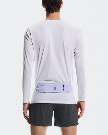 Person wearing a white long-sleeve shirt and black shorts with a visible brand logo on a white background - On Speed Belt (Unisex) - Thistle