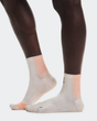 White socks with pink accents worn by a person on a white background - On Performance Run Sock Mid (Unisex) - Pearl/Sunstone