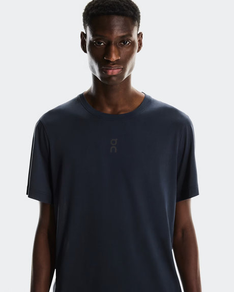 Man wearing a navy blue t-shirt with a brand logo on a light gray background - On Trail-T (Men's) - Navy