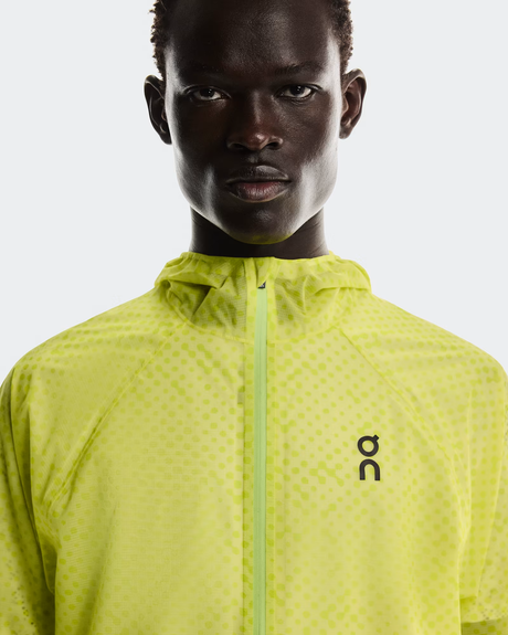 Person wearing a bright yellow jacket with a brand logo on a white background - On Ultra Jacket (Men's) - Limelight/Lime