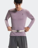 Person wearing a light purple long-sleeve athletic shirt and gray shorts on a white background - On Speed Belt (Unisex) - Fog