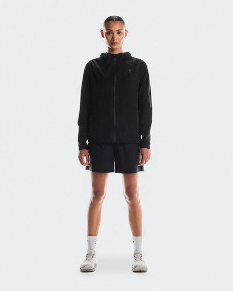 Person wearing a black hoodie and shorts on a white background - On Performance Jacket (Women's) - Black