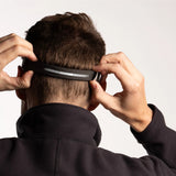 Person adjusting a black headband on a plain background - Biolite Range 500 Headlamp - Midnight Grey