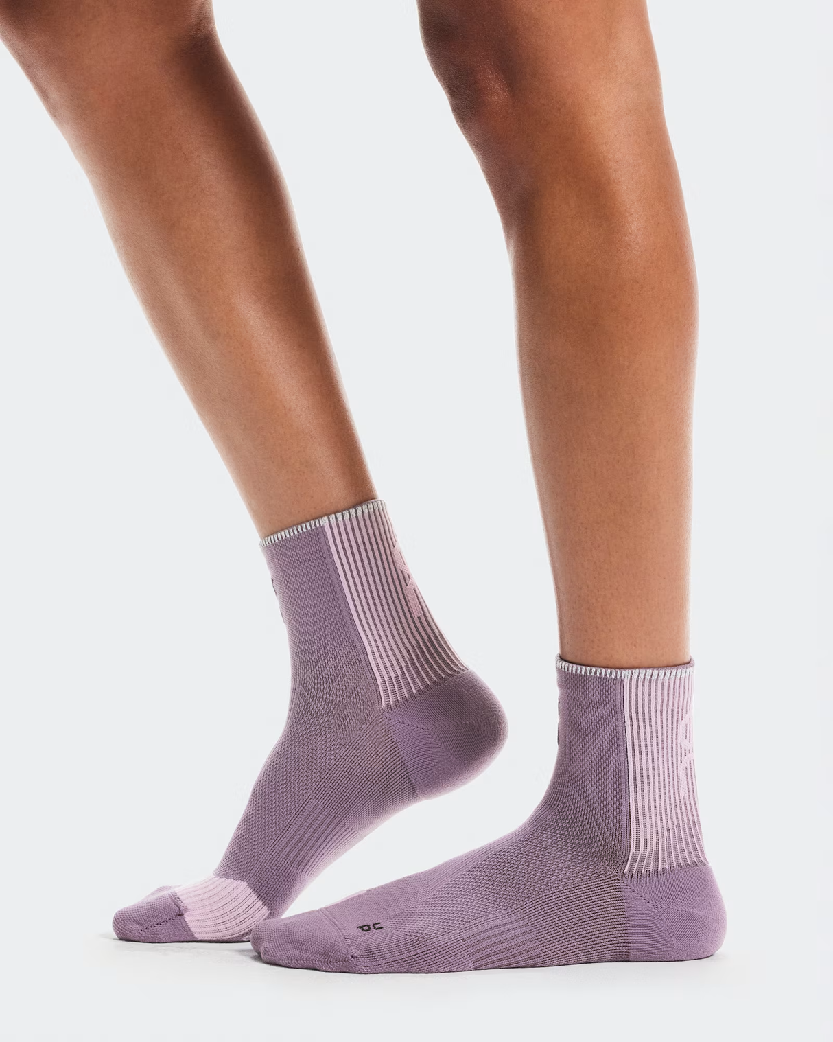 Purple socks worn by a person on a white background - On Performance Run Sock Mid (Unisex) - Dewberry/Sakura