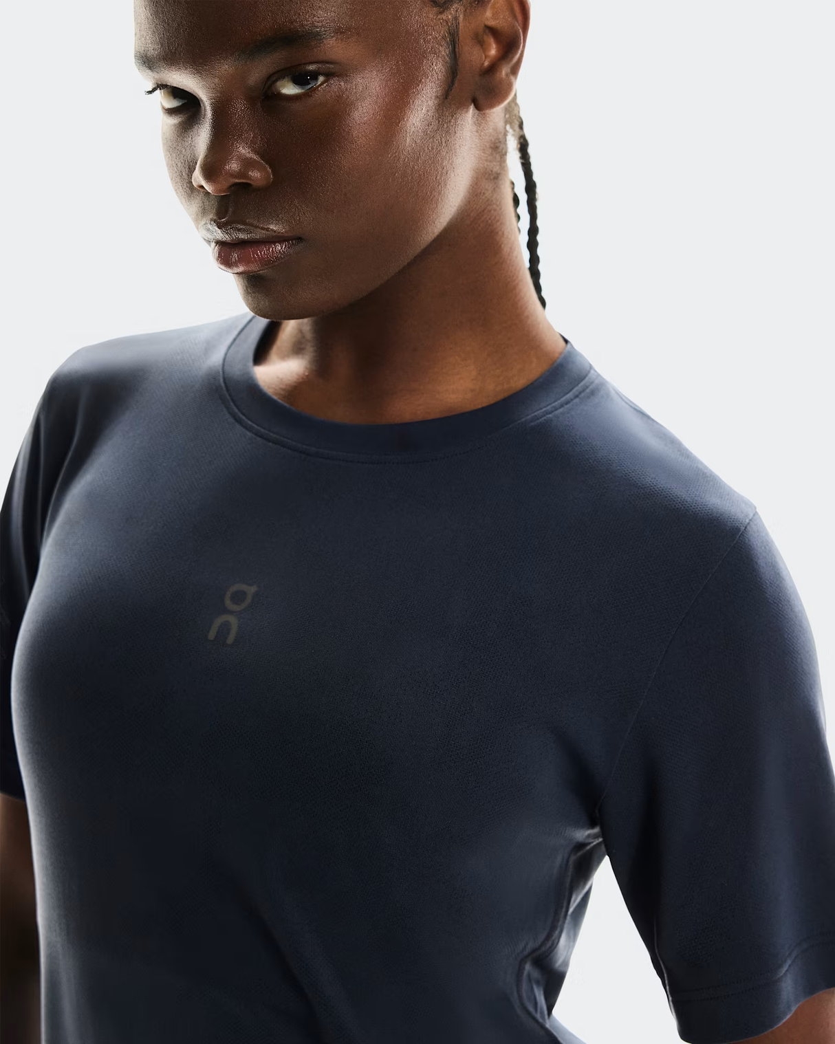 Person wearing a dark blue athletic shirt with a logo on a light gray background - On Trail-T (Women's) - Navy